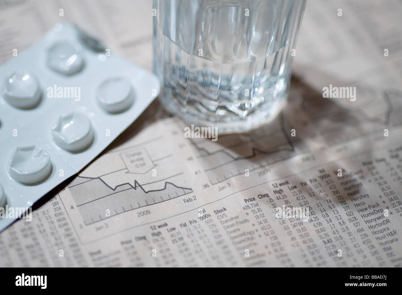 The financial page, a blister pack and a glass of water Stock Photo