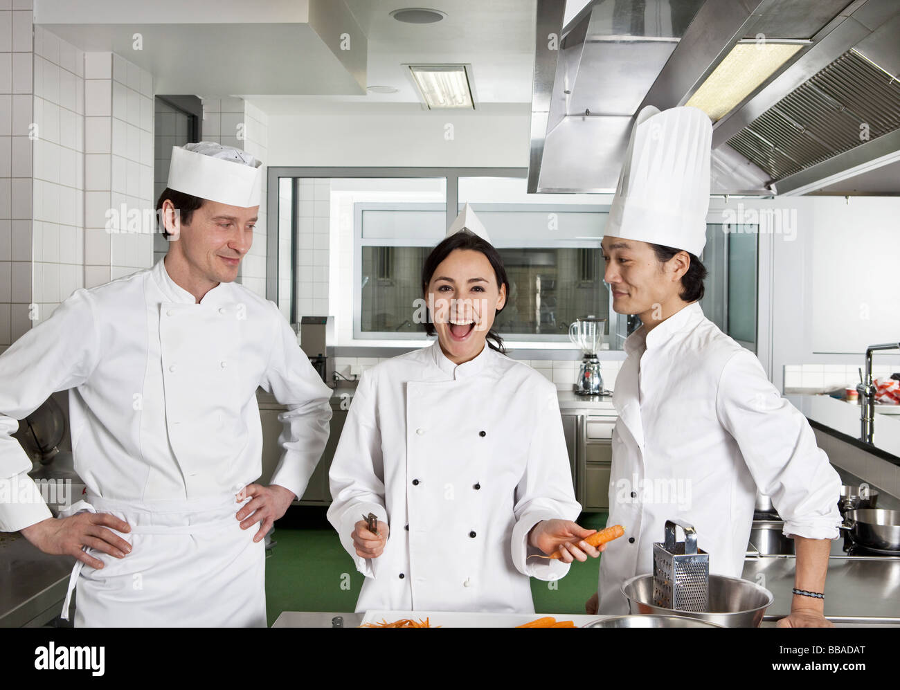 Two chefs teasing another chef Stock Photo