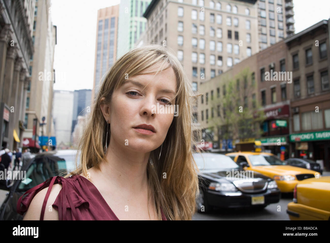 Portrait of a young woman standing on a city street, New York City ...