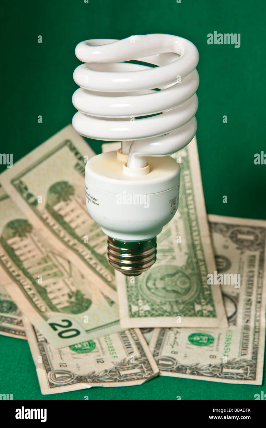 White Energy saving light bulb with paper money denoting savings Stock Photo