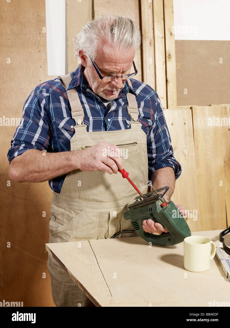 A man adjusting a power jigsaw Stock Photo