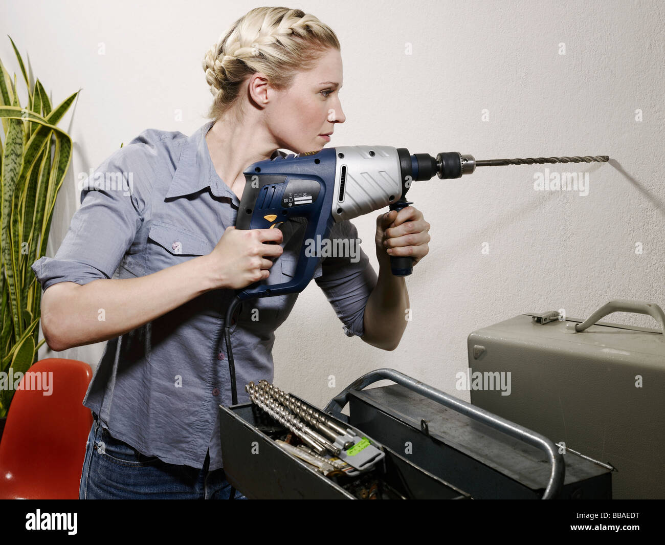 woman drilling into a wall Stock Photo 