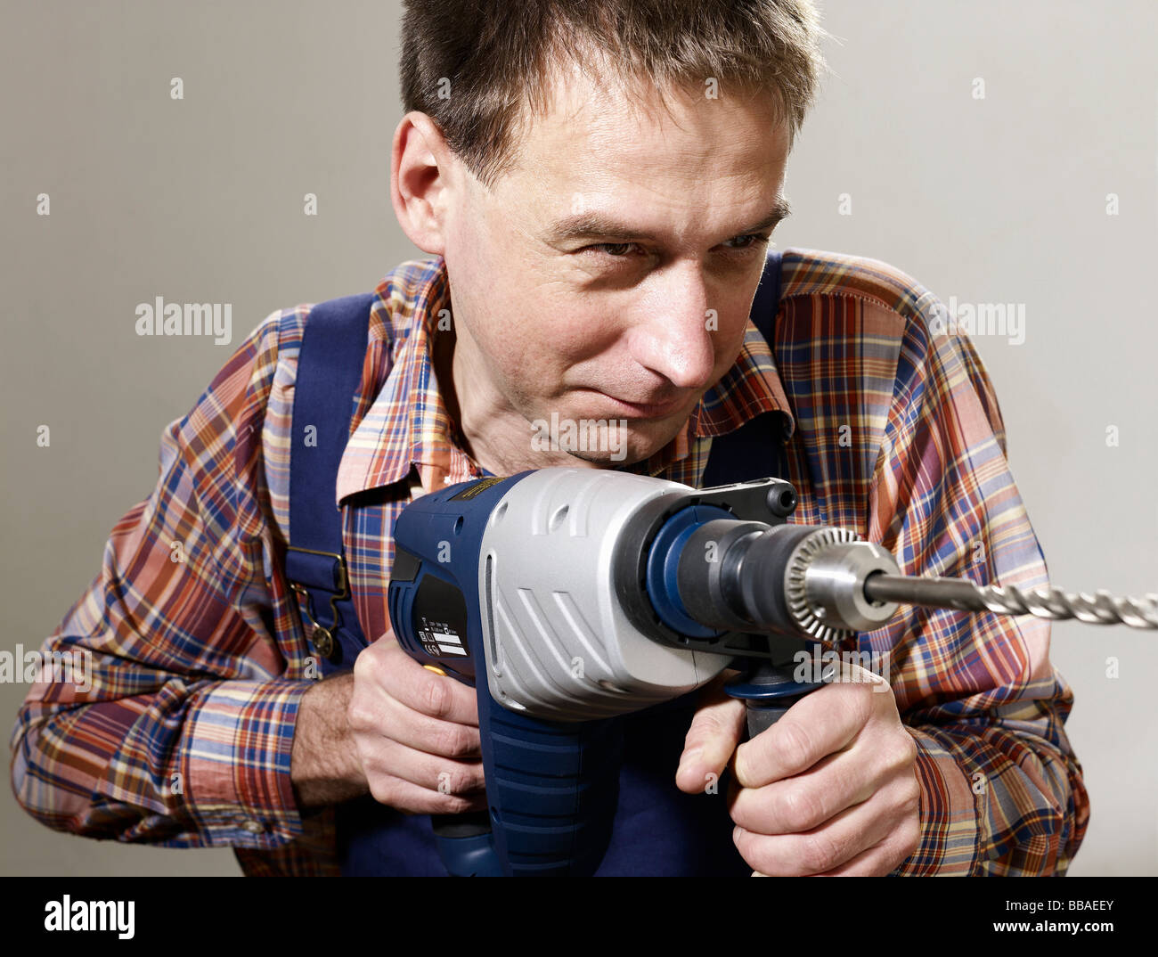 A man using a large drill Stock Photo