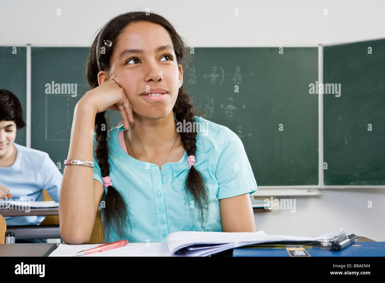 A schoolgirl sitting at a desk Stock Photo
