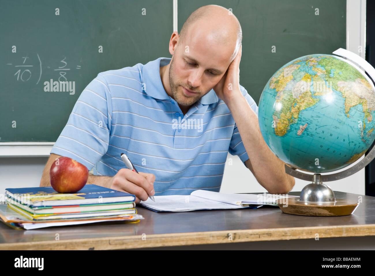A teacher working at a desk Stock Photo