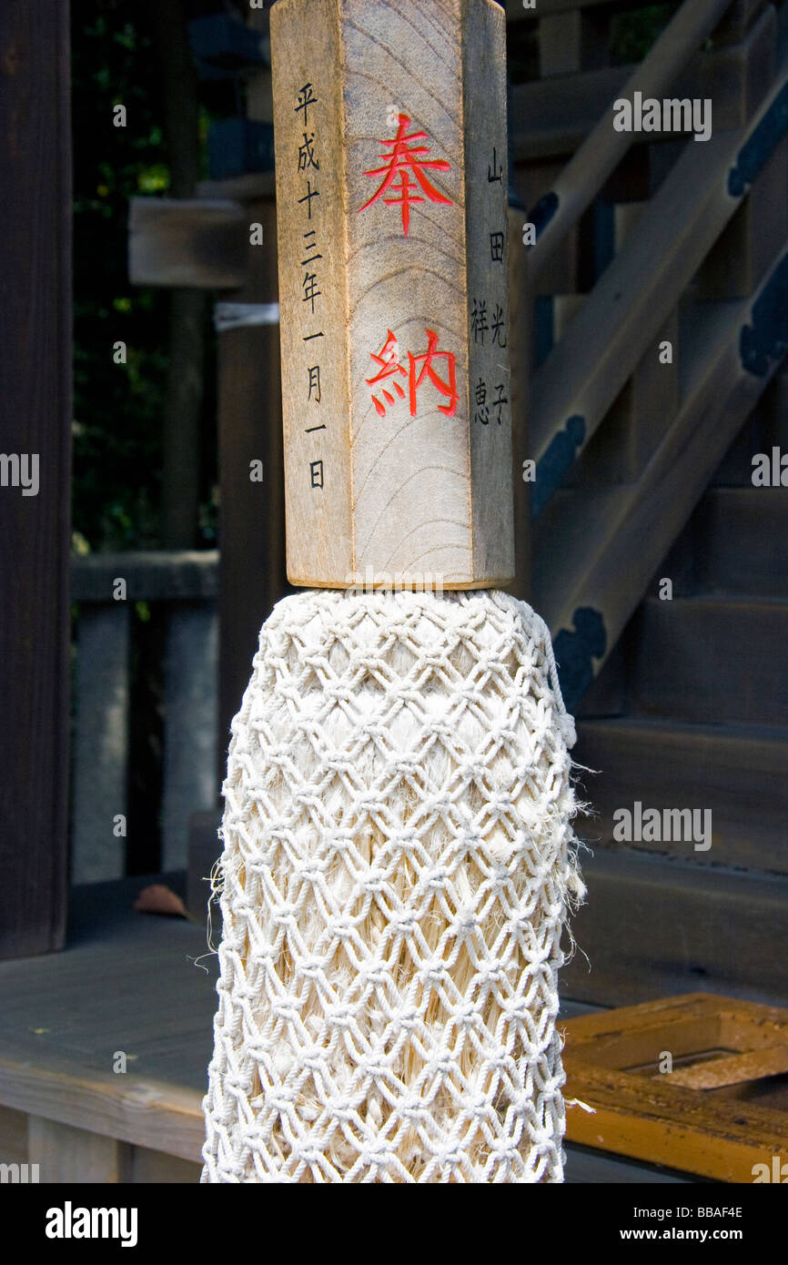 The wooden hand hold on a Japanese bell rope at Yasaka shrine in Kyoto. Wooden handle with red and black kanji characters, plaited rope below. Stock Photo
