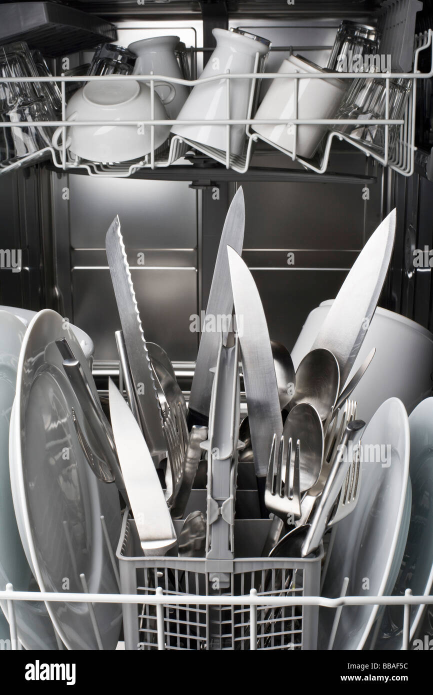 A dishwasher with knives sticking dangerously point side up Stock Photo