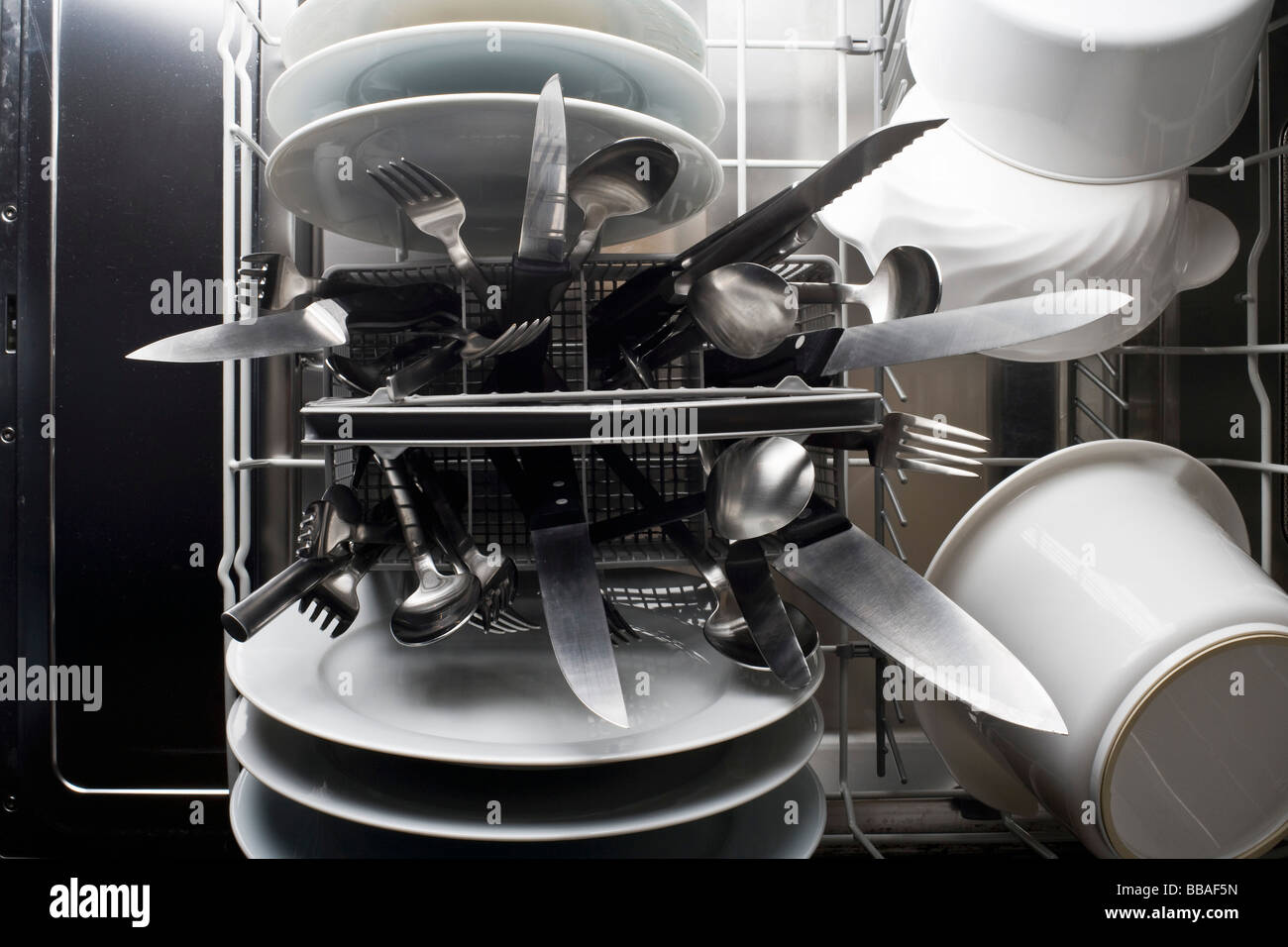 A dishwasher with knives sticking dangerously point side up Stock Photo