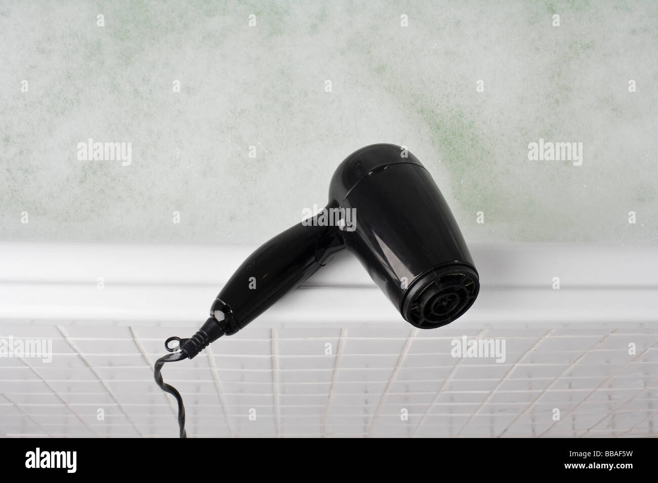A hair dryer balancing on the edge of a full bathtub Stock Photo Alamy
