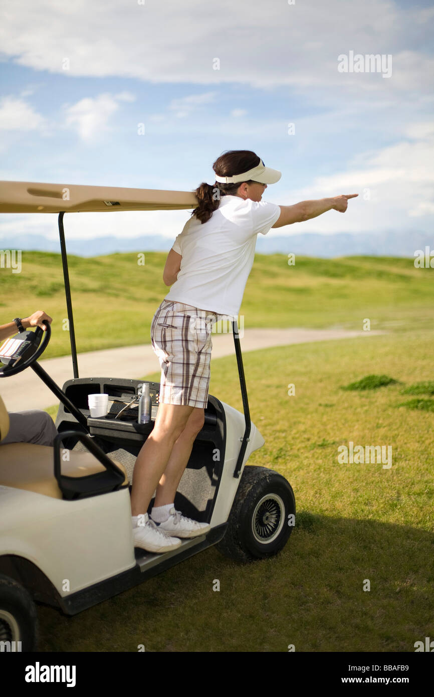 A golfer pointing from a golf cart, Palm Springs, California, USA Stock