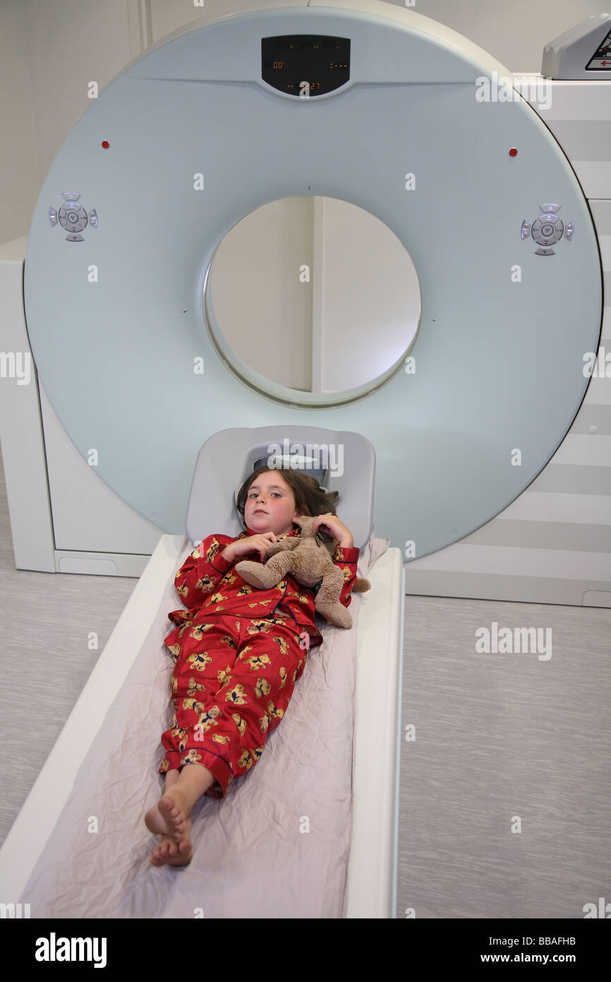 Child holding teddybear while waiting for CT scan Stock Photo