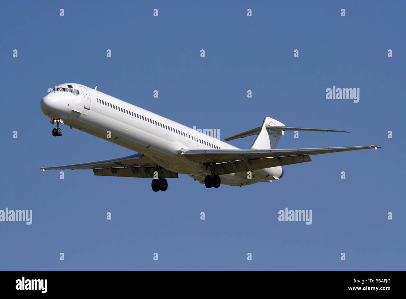 Commercial air travel. Airliner on final approach with no livery and proprietary details deleted Stock Photo