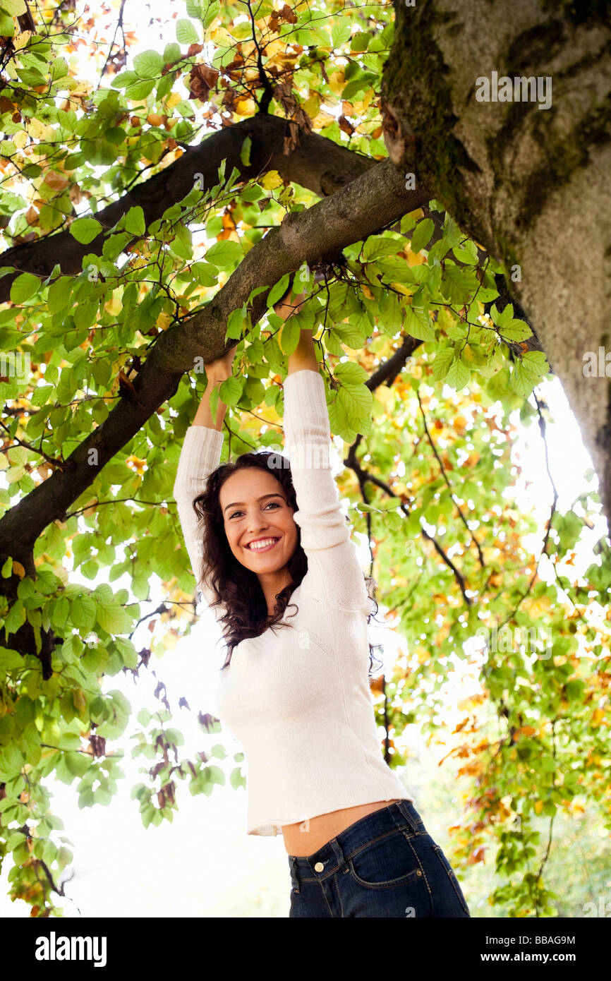 young woman hanging on tree Stock Photo
