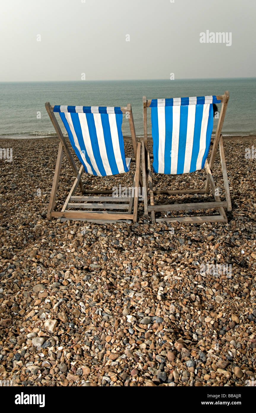 deckchairs on brighton beach while are available to hire so you can sit and sunbathe Stock Photo