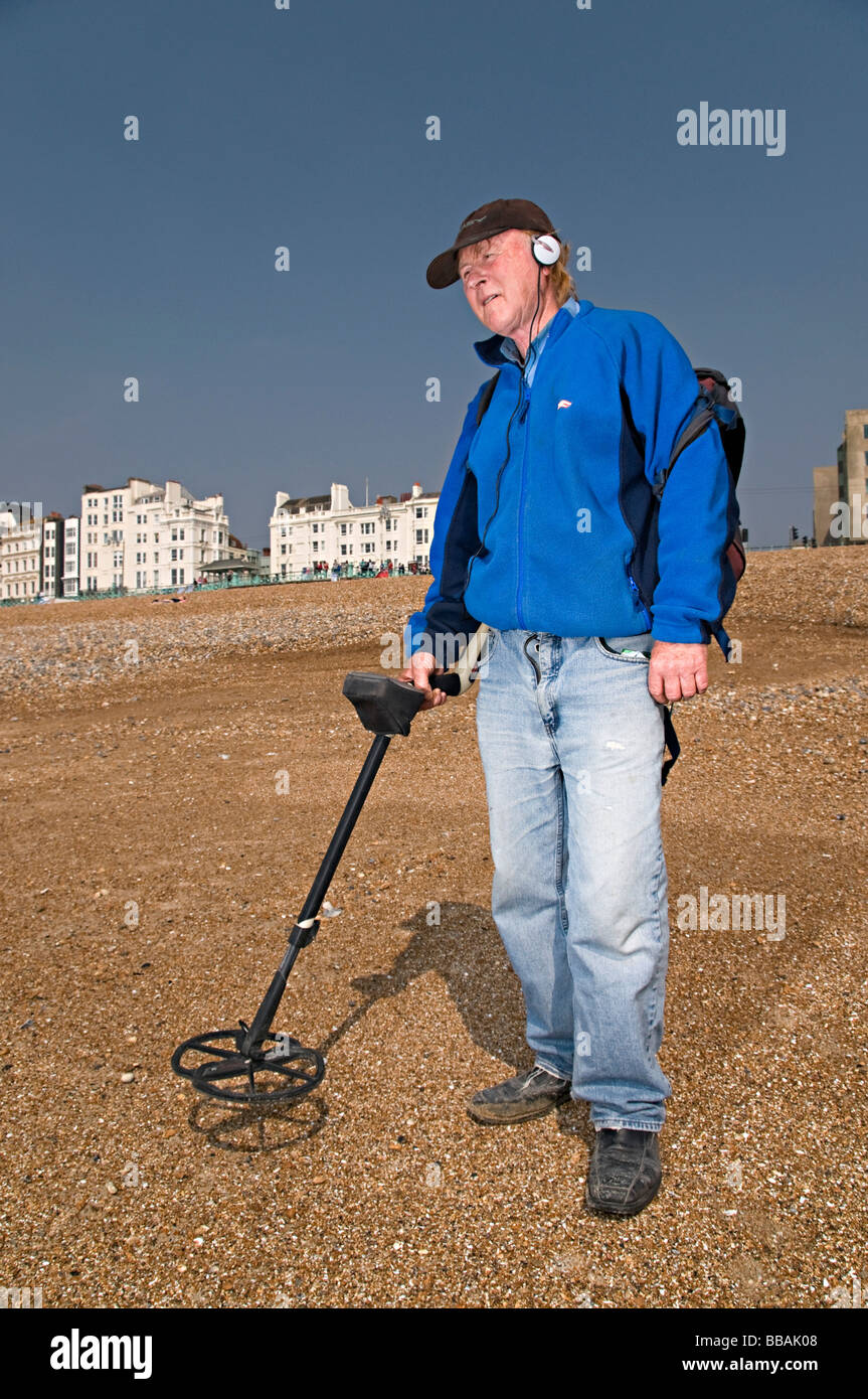 a metal detecting man on brighton beach trying to find money Stock