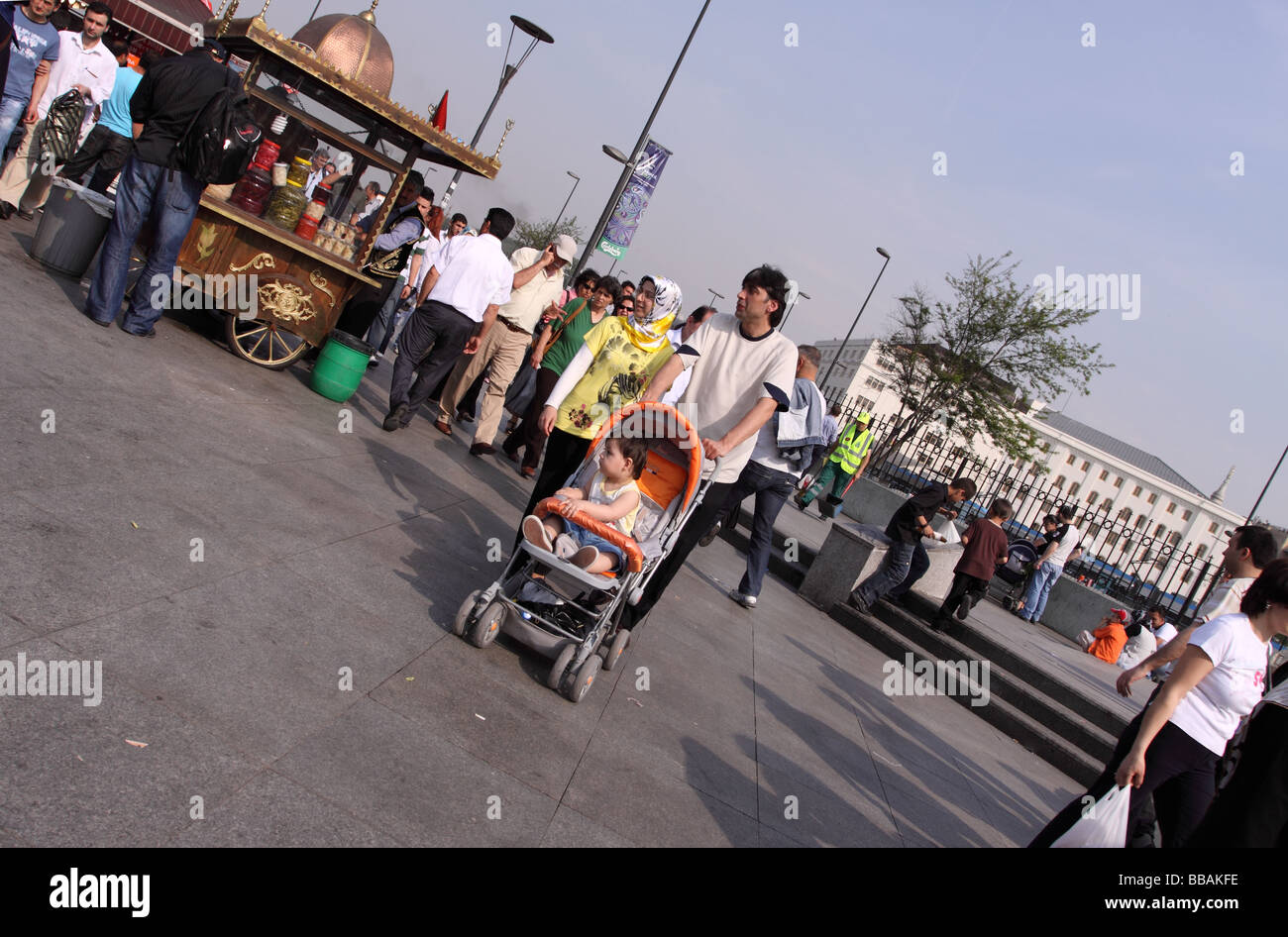 Istanbul Turkey modern Turkish man with baby push chair pram buggy at the Eminonu waterfront Stock Photo