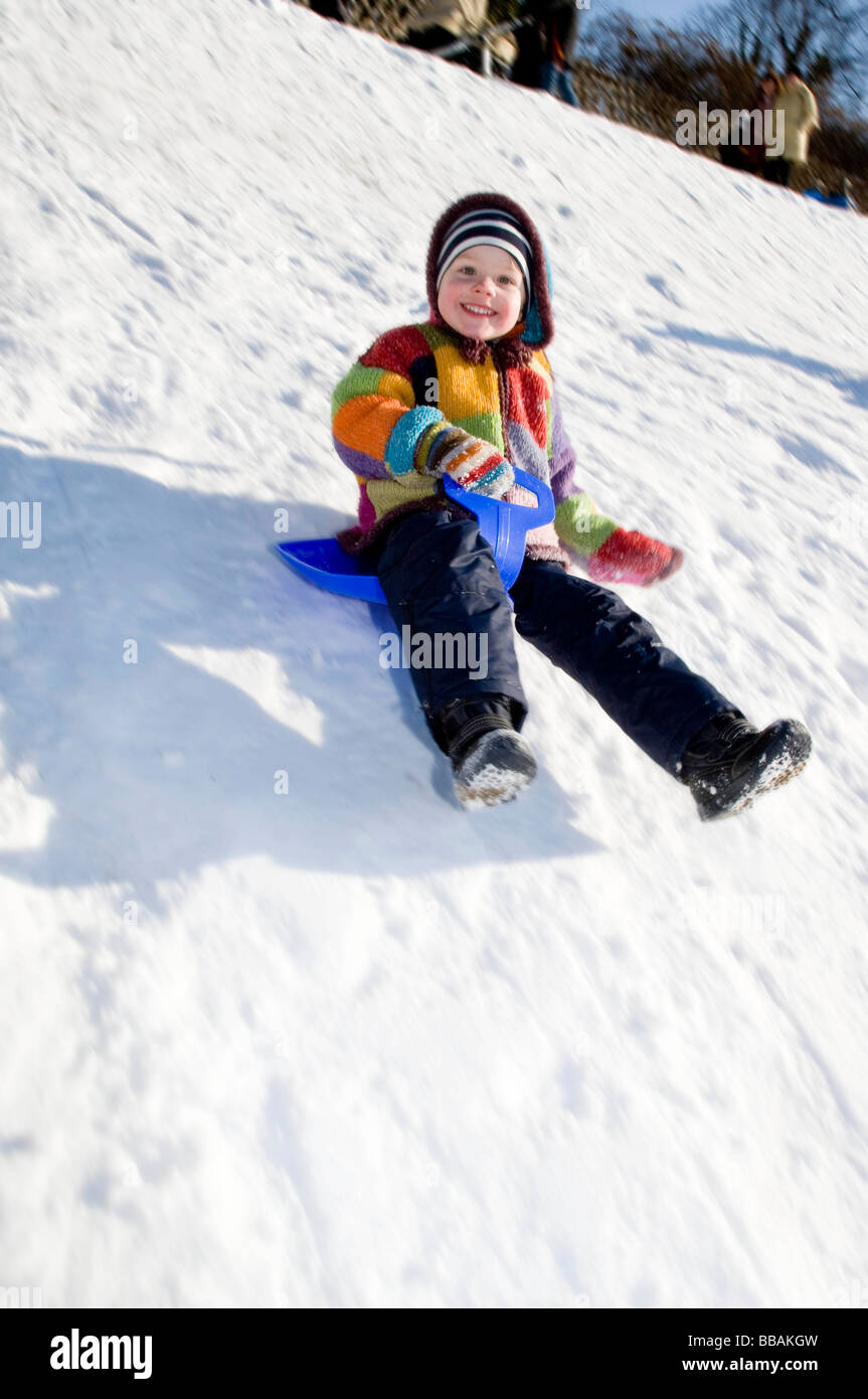boy riding a sledge in snow Stock Photo - Alamy