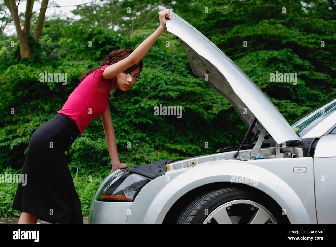 woman checking engine of car, hood up, on side of road Stock Photo Alamy