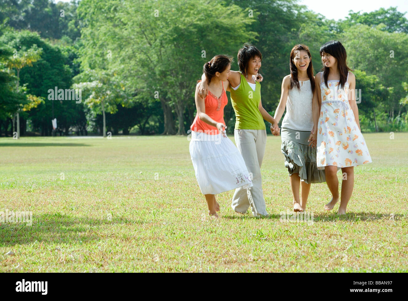 Young women in park, walking side by side Stock Photo - Alamy