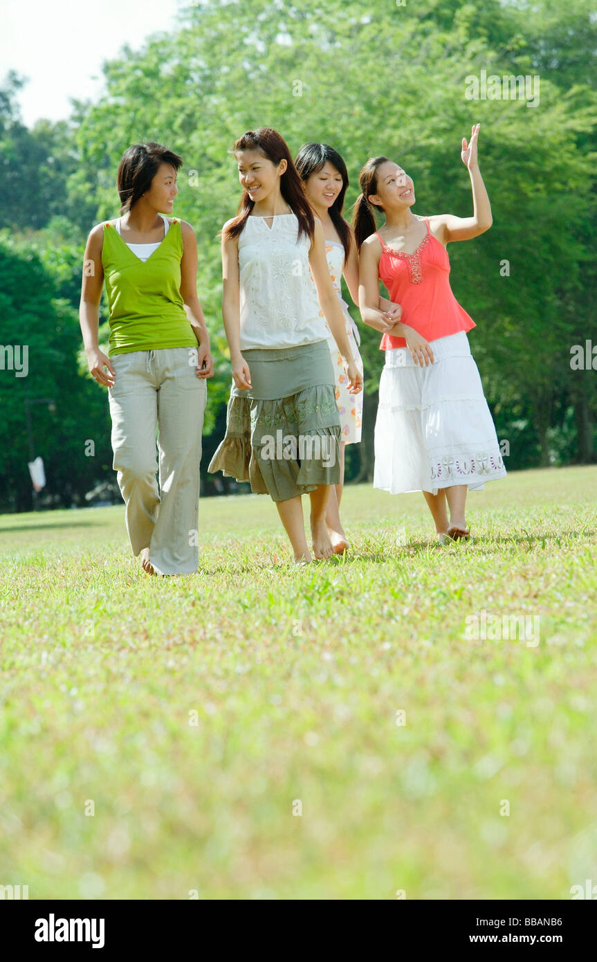Four young women walking in park Stock Photo - Alamy