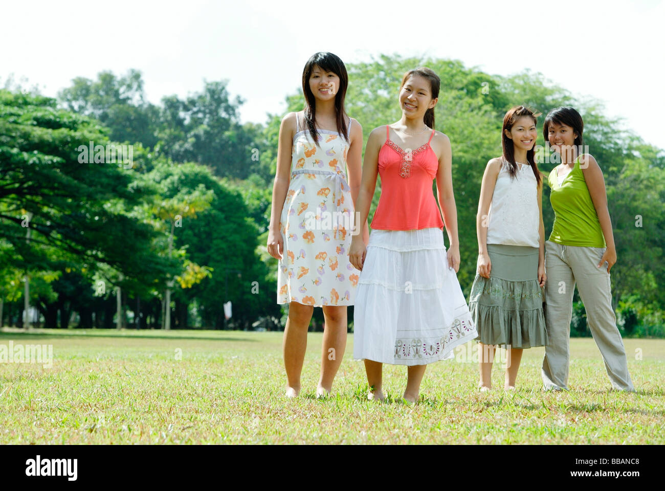 Young women standing side by side in field Stock Photo - Alamy