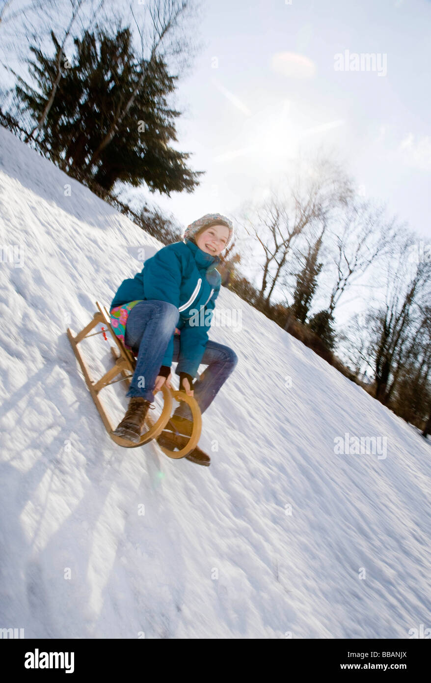 Girl riding a sledge in snow Stock Photo - Alamy