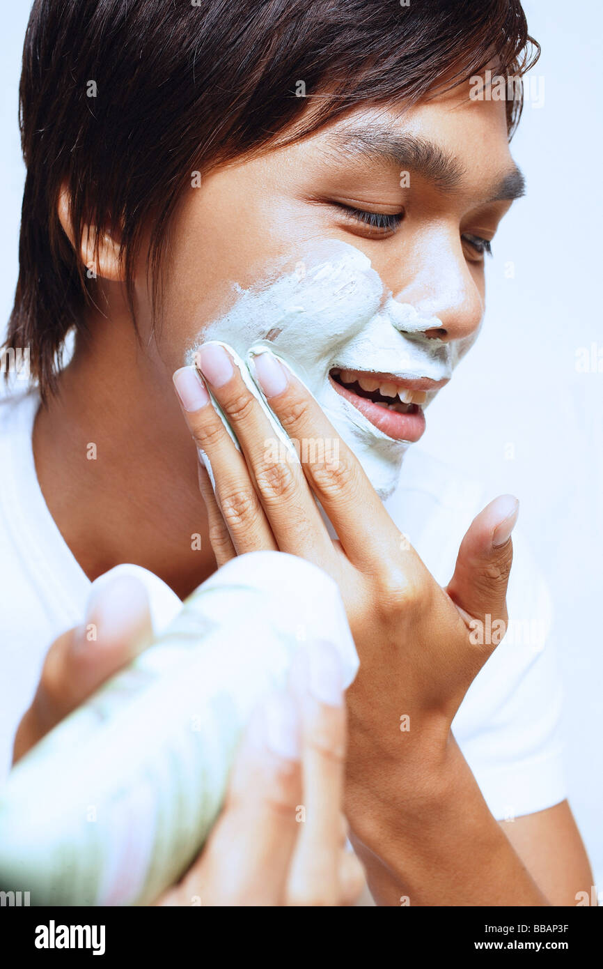 Young man applying shaving foam on face Stock Photo Alamy