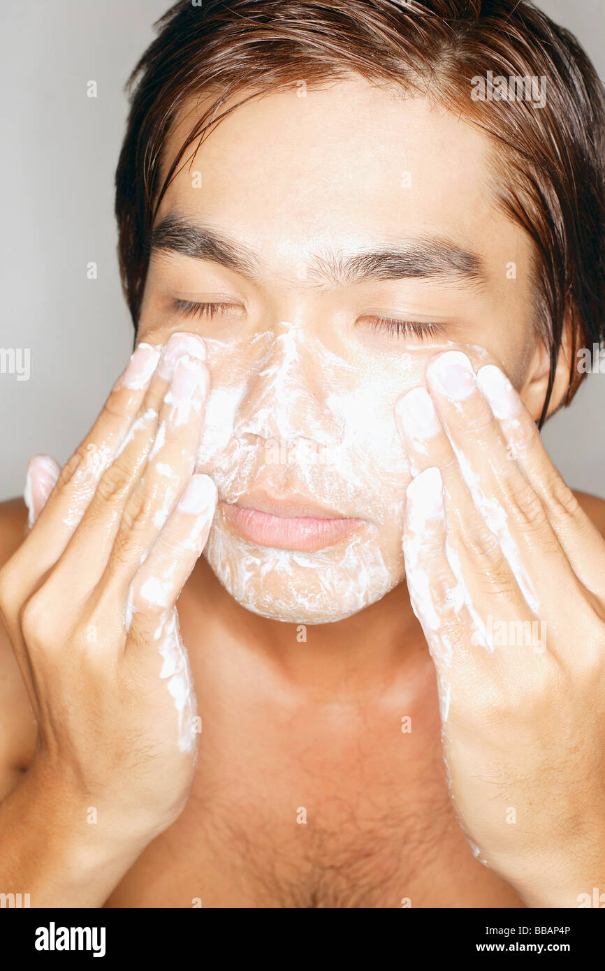 Young man washing face, eyes closed Stock Photo Alamy