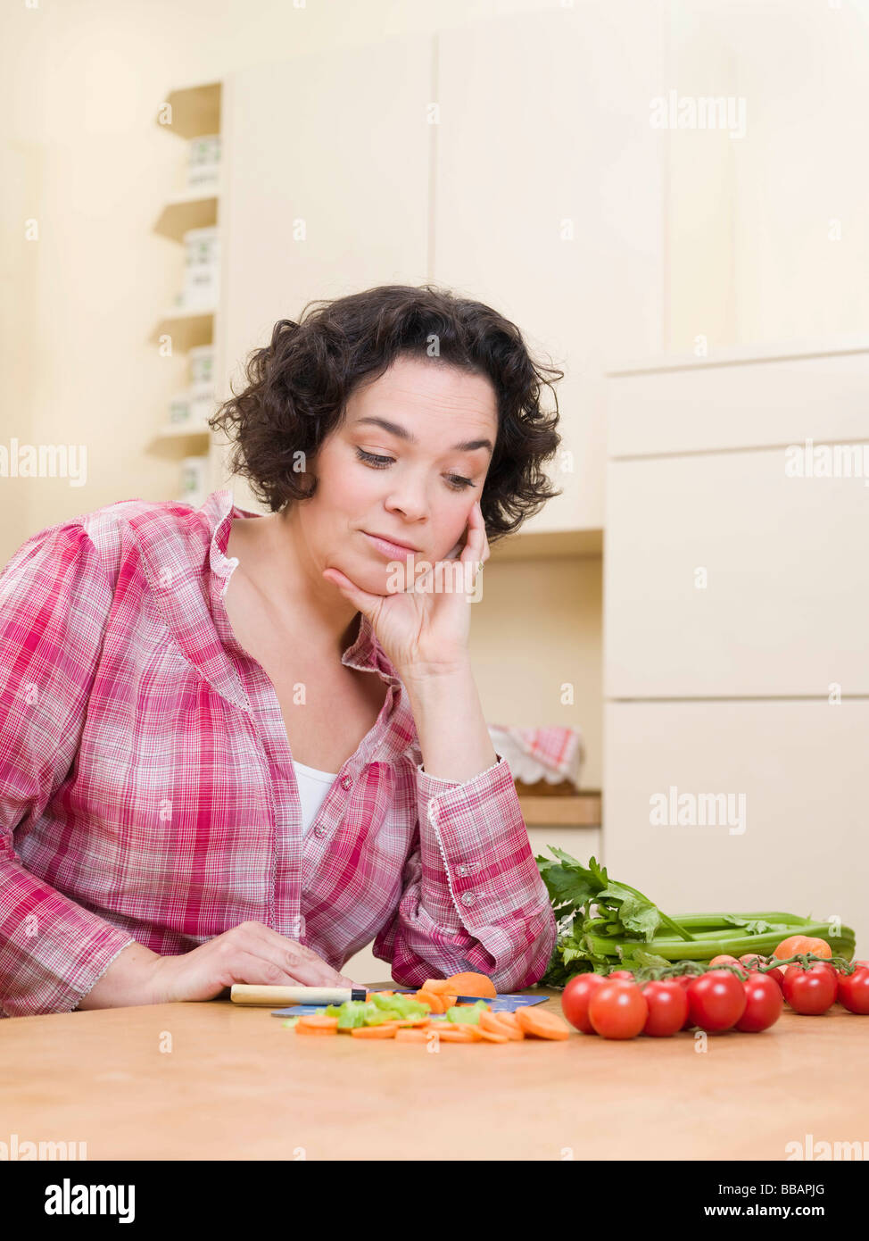 woman looking doubtfully at vegetables Stock Photo