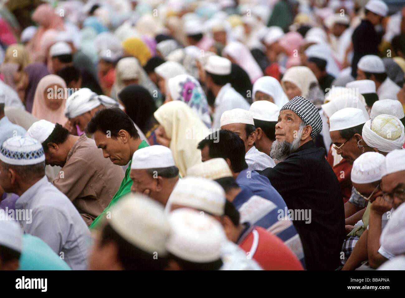 Malaysia, Kota Bahru, Muslims sit on dusty streets to listen to Pan -Malaysian Islamic Party speech. Stock Photo