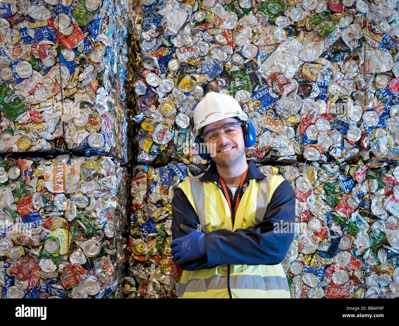 Recycle Worker With Bales Of Tin Cans Stock Photo