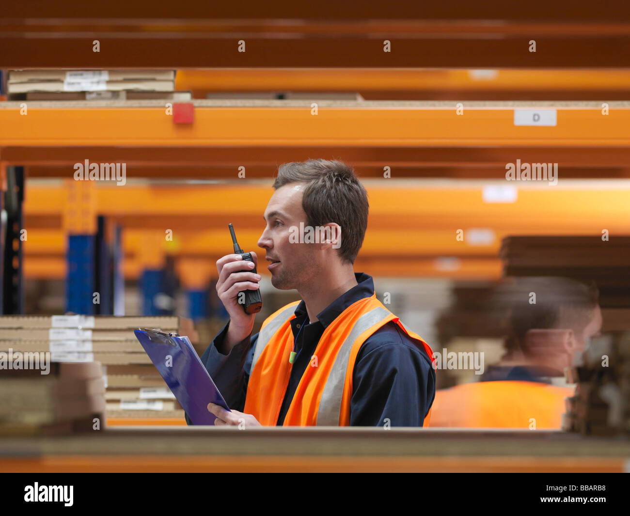 Worker On Walkie Talkie In Warehouse Stock Photo - Alamy