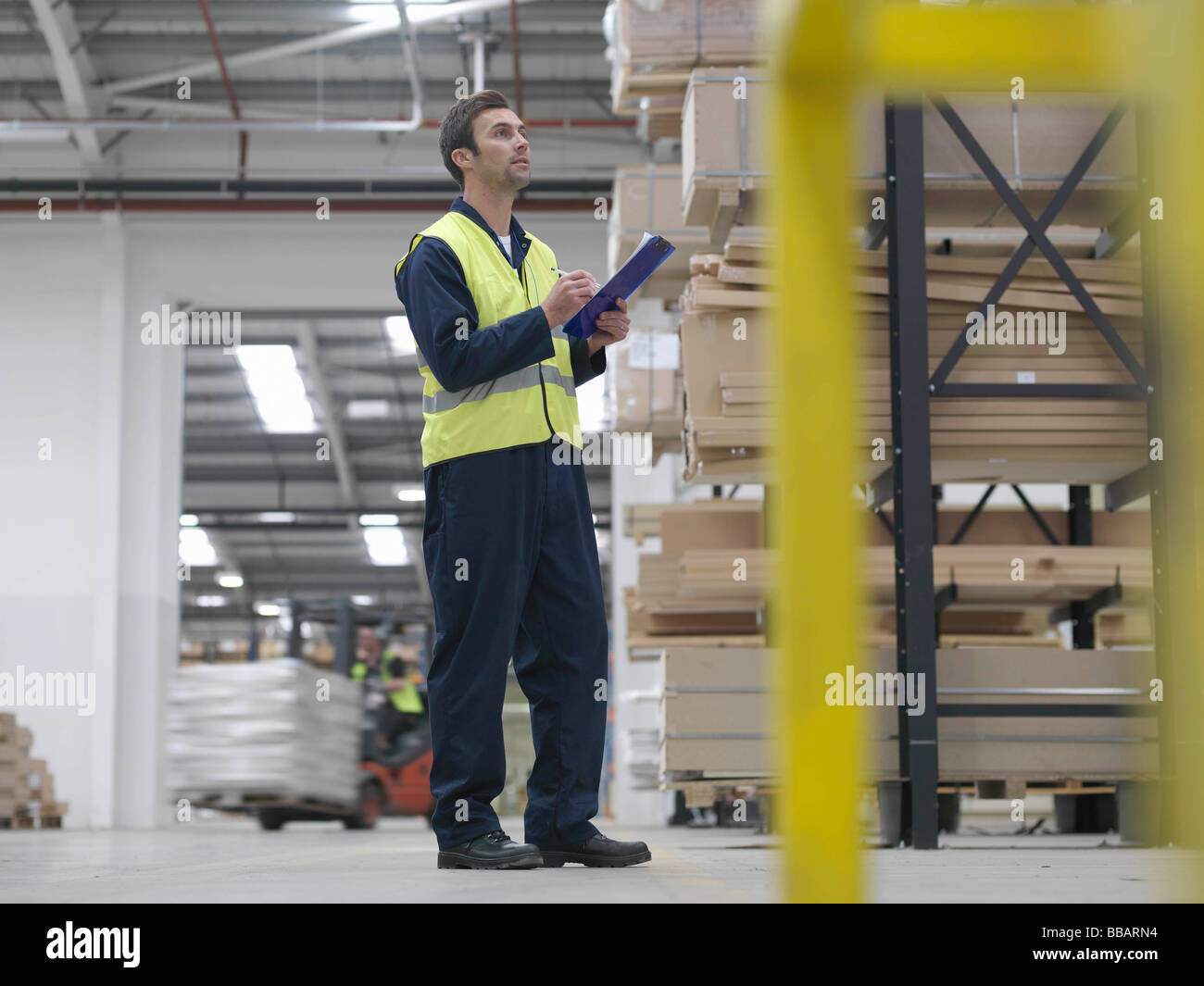 Worker With Clipboard In Warehouse Stock Photo