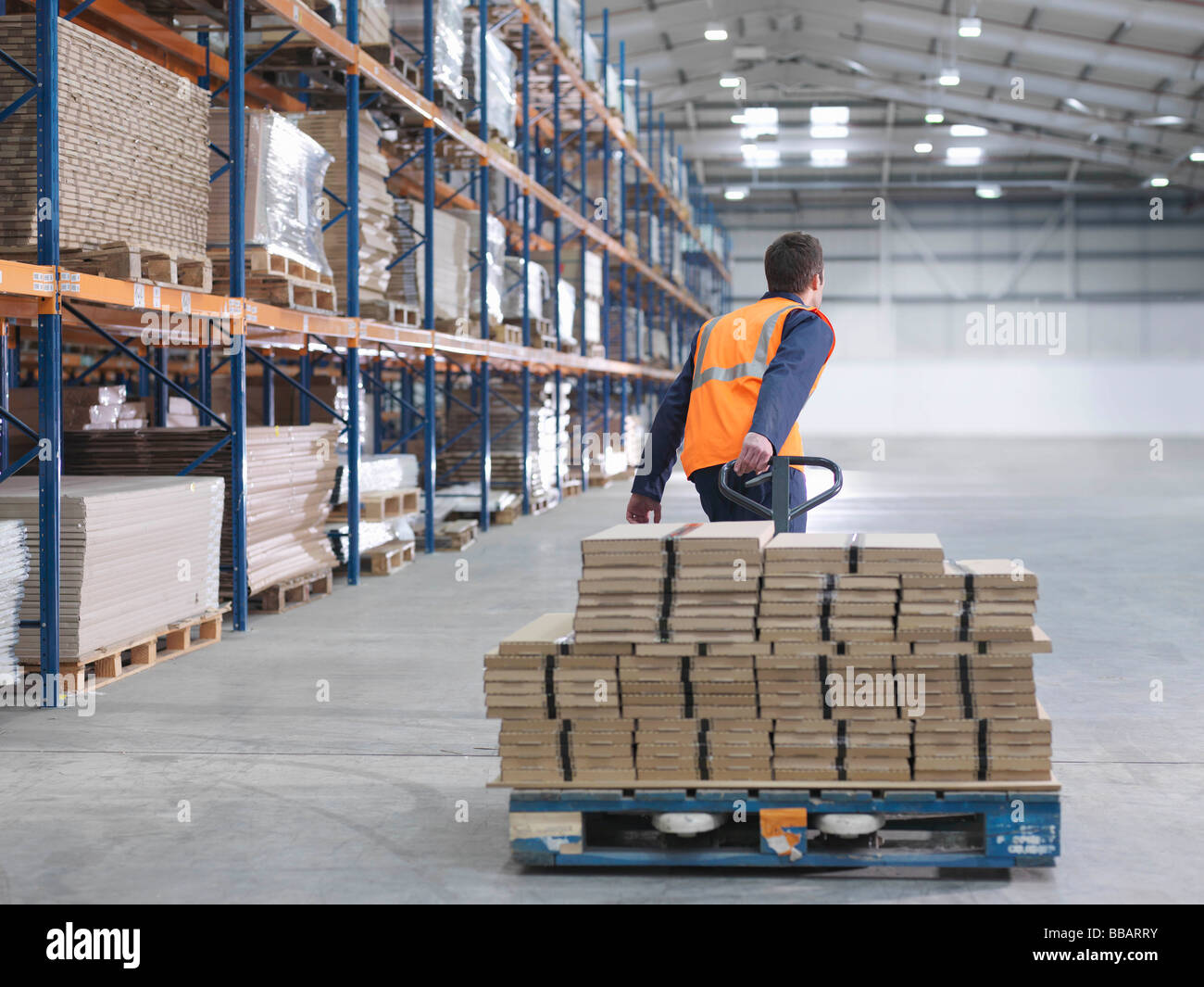 Worker Transporting Load In Warehouse Stock Photo
