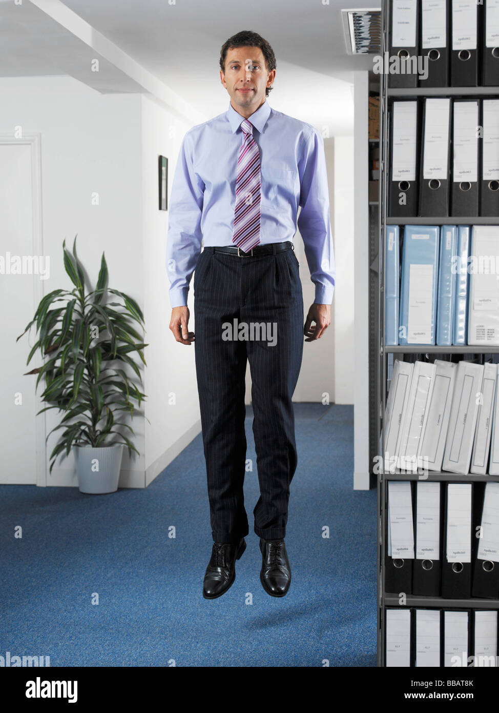 Office worker jumping in office Stock Photo