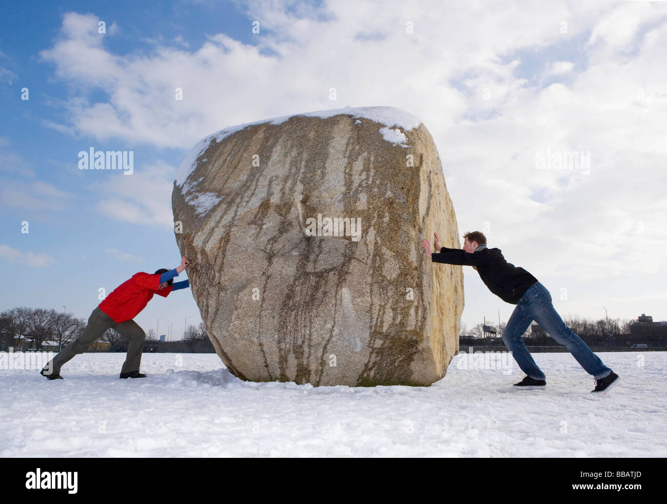 2 men pushing boulder Stock Photo - Alamy