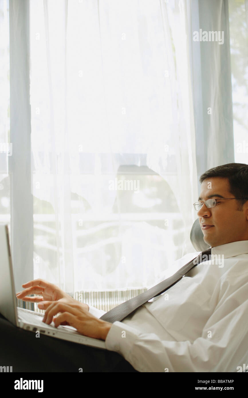 Businessman reclining on chair, using laptop Stock Photo Alamy