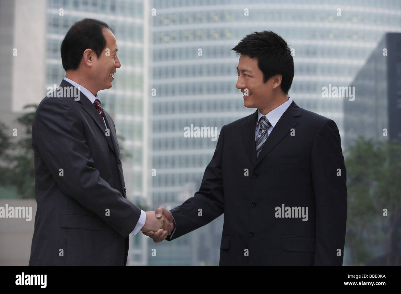 Two Chinese businessmen shake hands in China Stock Photo