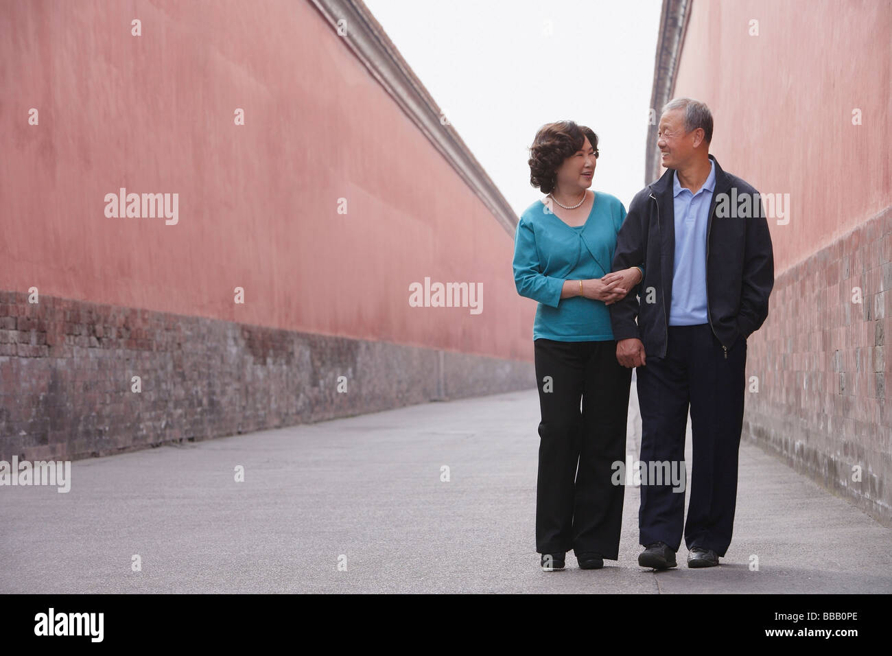 A man and woman link arms as they walk together Stock Photo Alamy