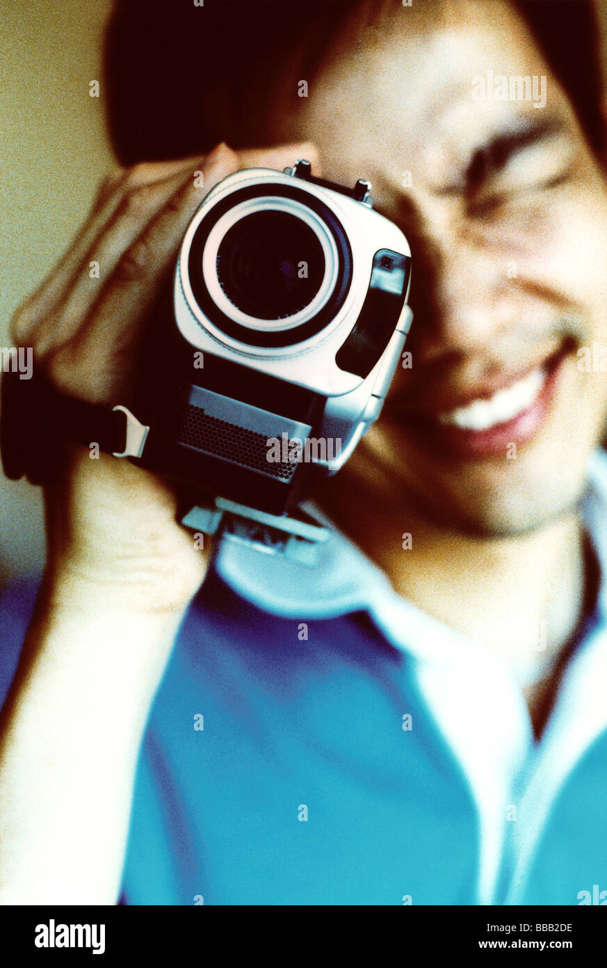 Man looking into viewfinder of camcorder Stock Photo Alamy