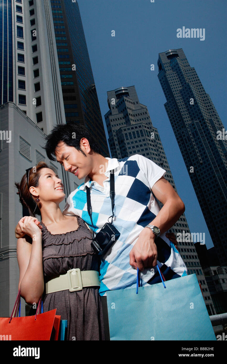 A couple walk with their arms around each other as they shop Stock Photo