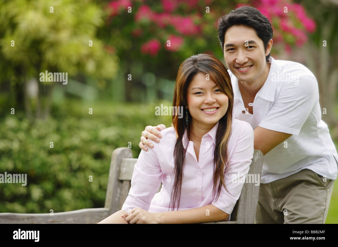 Couple in park, looking at camera Stock Photo - Alamy