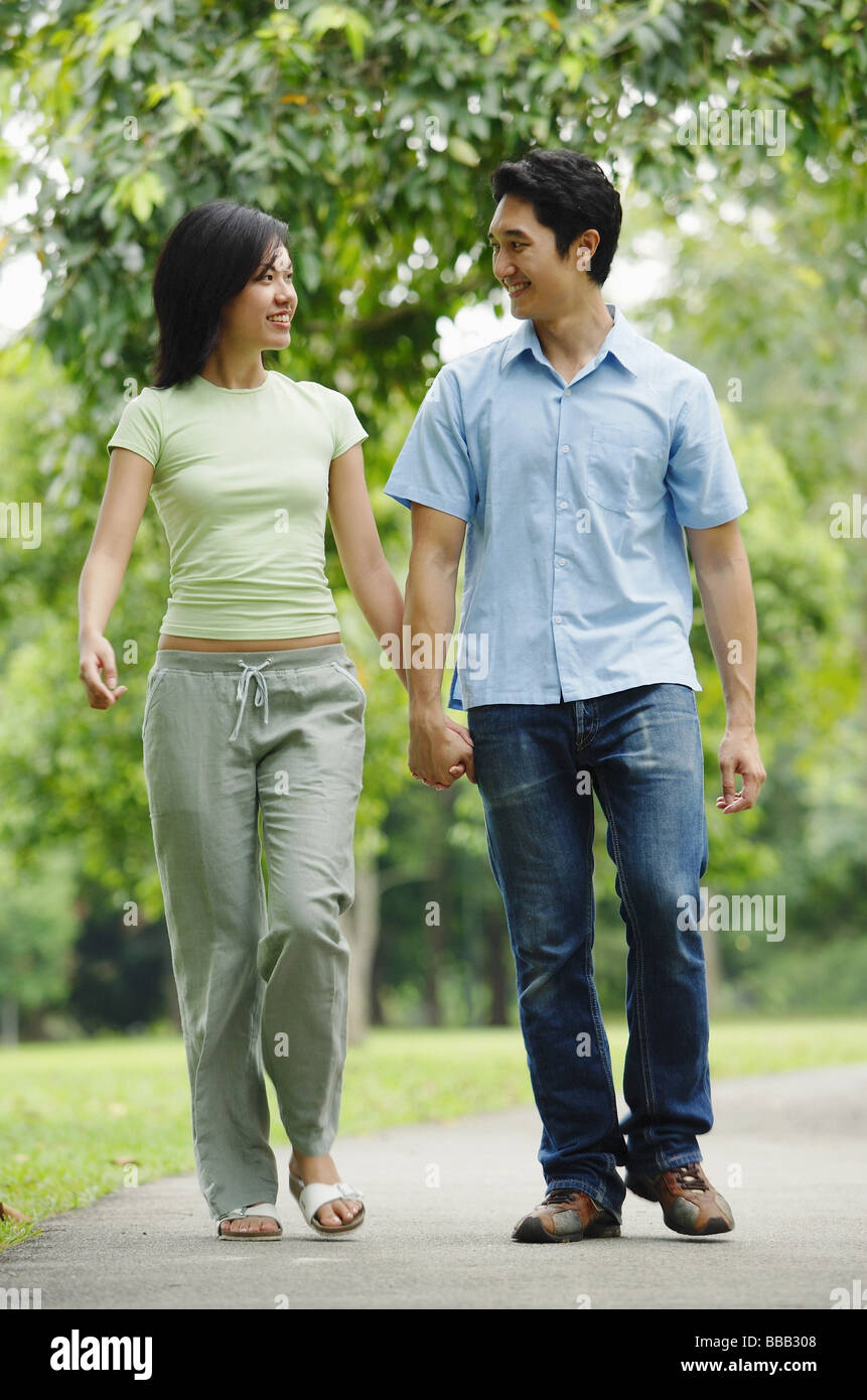 Couple holding hands and walking in park Stock Photo - Alamy
