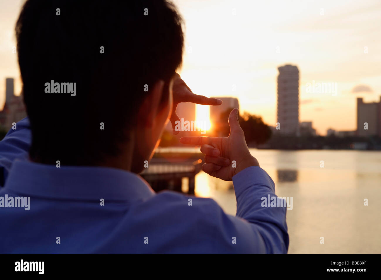 Back view of young man framing picture with fingers Stock Photo