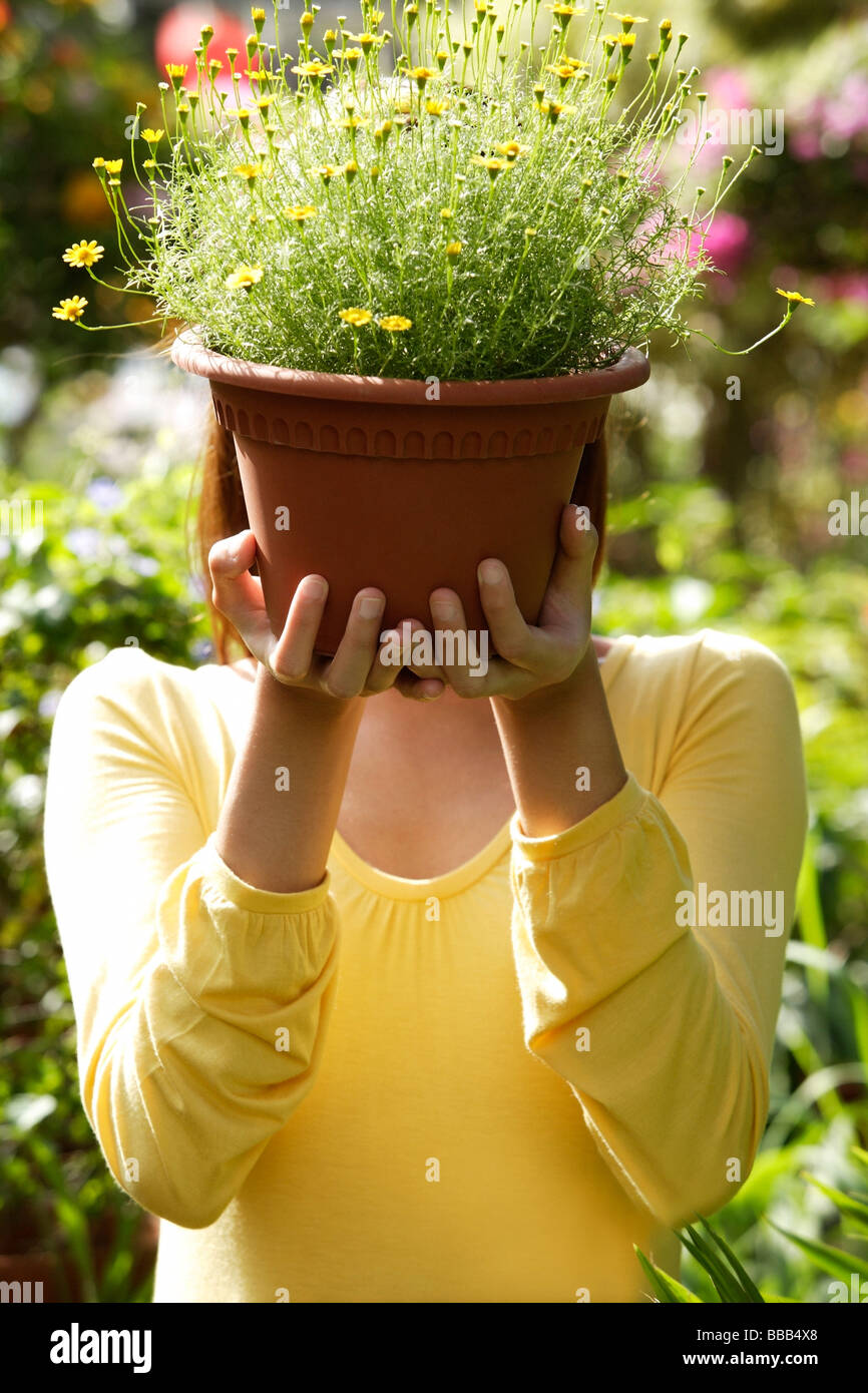 Young woman at nursery, holding potted plant Stock Photo - Alamy