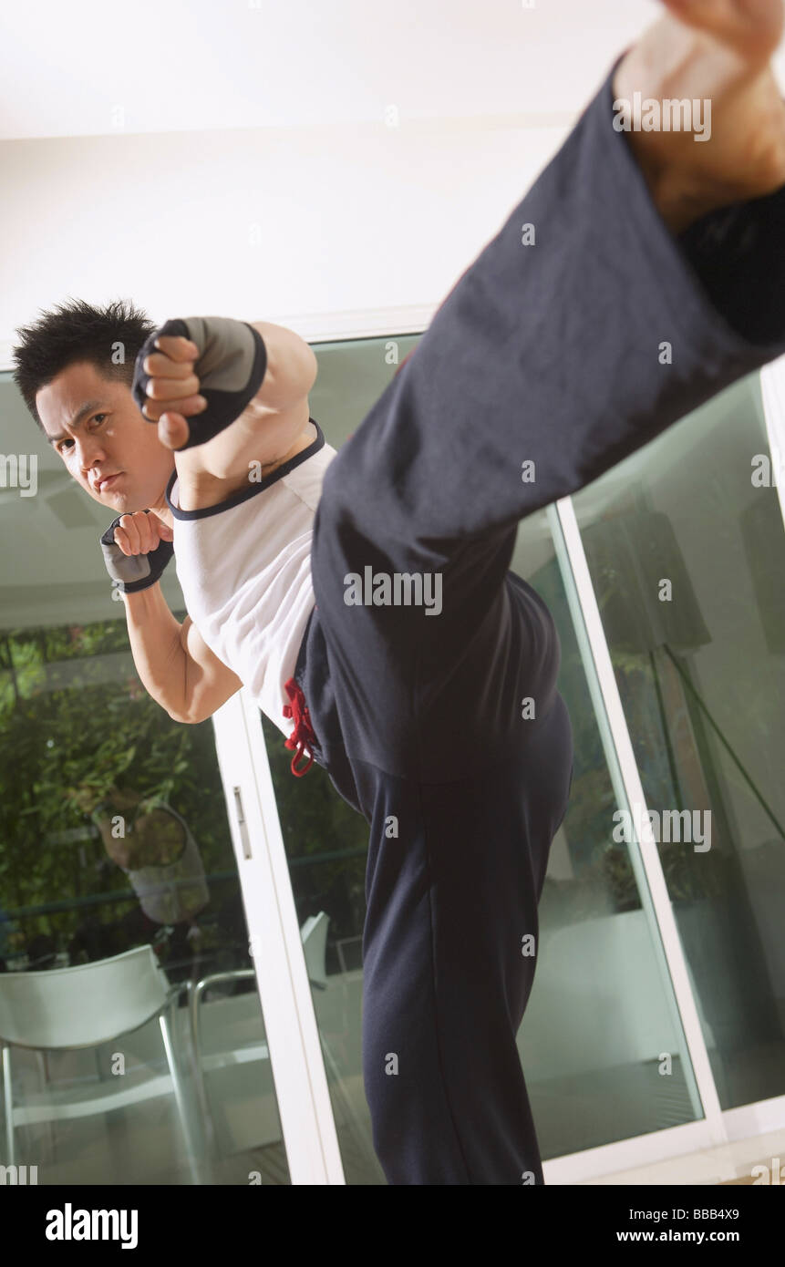 Man practicing martial arts, kicking Stock Photo