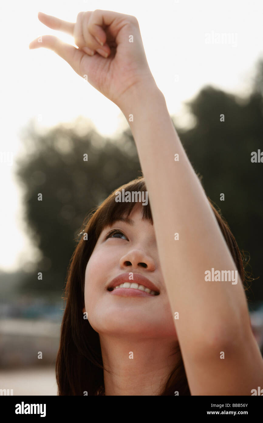 Young woman holding sunlight with her fingers Stock Photo - Alamy