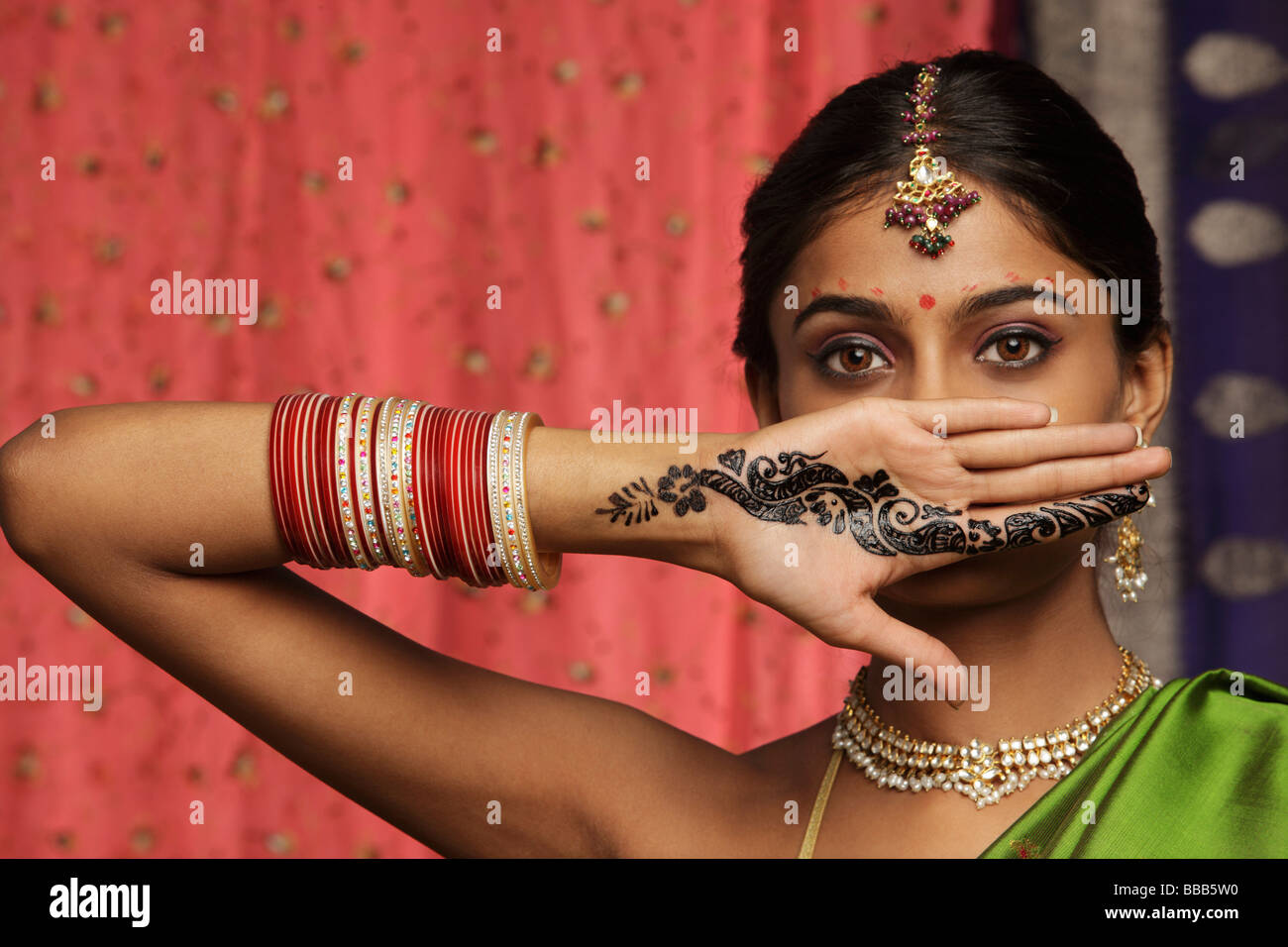 woman with hands decorated in henna, standing against wall of sari fabric  Stock Photo - Alamy