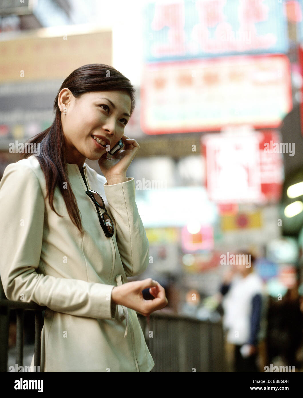 Woman using cellular phone in busy street. Stock Photo