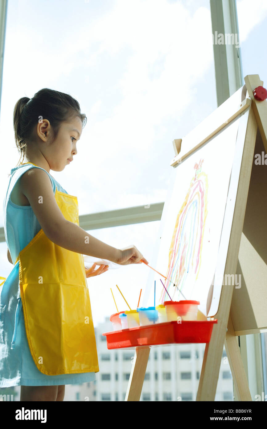 Young girl standing in front of easel, painting Stock Photo - Alamy